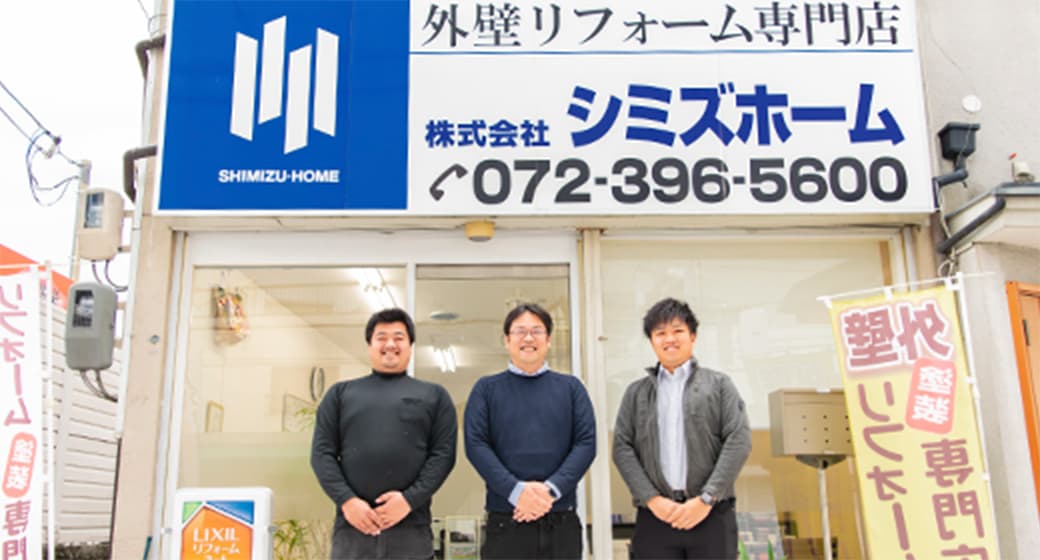 株式会社シミズホーム外観と、スタッフ3名が並んだ写真