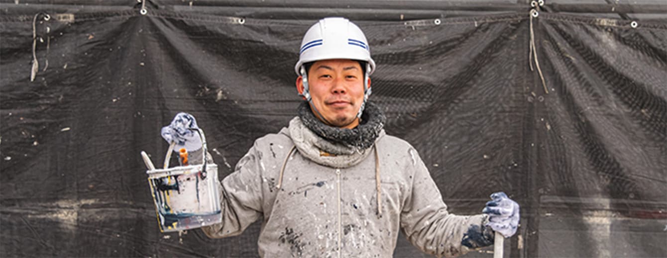 塗装道具を手に持つ職人の写真