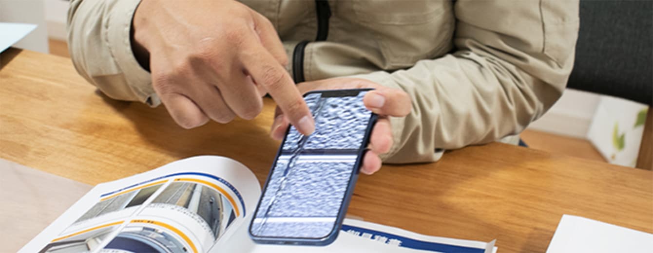 外壁の写真を指差しながら商談をする様子